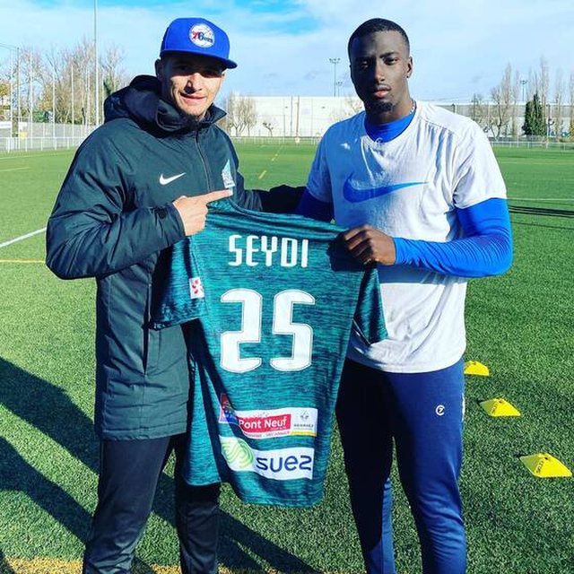 Coach Salim et un joueur tenant son maillot n°25